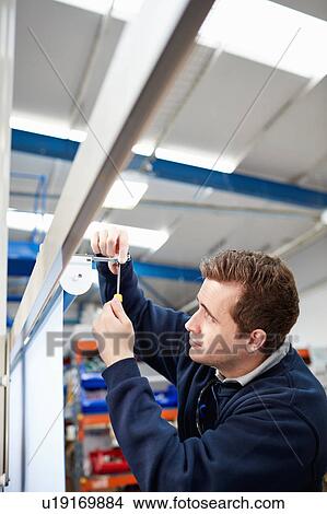 Male worker measuring roller blind in factory View Large Photo Image Picture - Male worker measuring roller blind in factory. Fotosearch