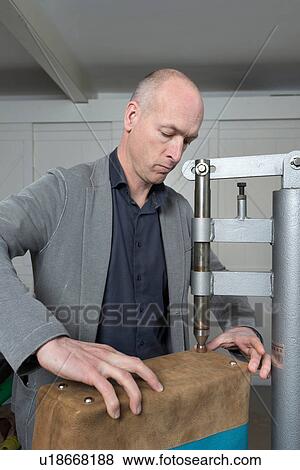 Man applying bag feet to leather holdall View Large Photo Image Stock Photo - Man applying bag feet to leather holdall. Fotosearch