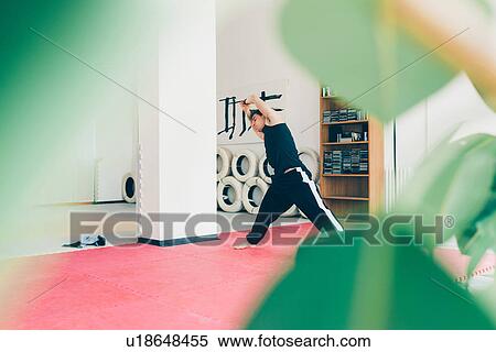Stock Photography - Man bending over sideways doing stretching exercises. Fotosearch