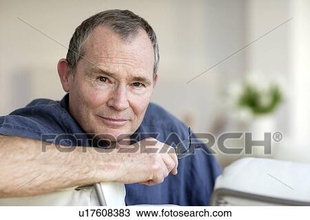 Stock Image - Man holding his glasses. Fotosearch