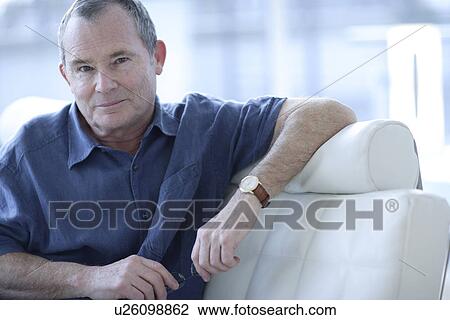 Stock Image - Man holding his glasses. Fotosearch