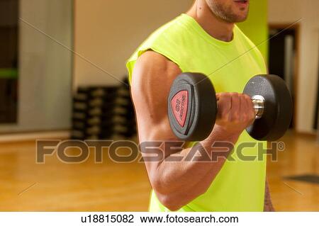 Man in gym using dumbbell View Large Photo Image Stock Image - Man in gym using dumbbell. Fotosearch