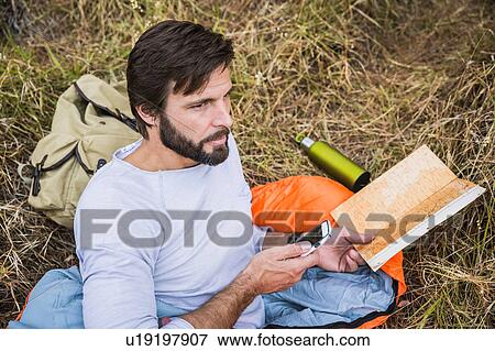 Man in sleeping bag planning with map and smartphone in forest, Deer Park, Cape Town, South Africa View Large Photo Image Stock Photo - Man in sleeping bag planning with map and smartphone in forest, Deer Park, Cape Town, South Africa. Fotosearch