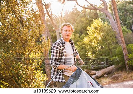Man putting up tent in forest, Deer Park, Cape Town, South Africa View Large Photo Image Stock Photo - Man putting up tent in forest, Deer Park, Cape Town, South Africa. Fotosearch