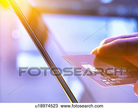Man using his credit card online for shopping and banking with sunlight coming through window View Large Photo Image Stock Image - Man using his credit card online for shopping and banking with sunlight coming through window. Fotosearch
