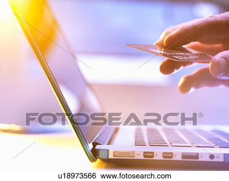 Man using his credit card online for shopping and banking with sunlight coming through window View Large Photo Image Stock Photograph - Man using his credit card online for shopping and banking with sunlight coming through window. Fotosearch