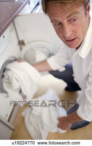 Stock Image - Man washing clothes. Fotosearch