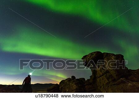 Stock Photo - Man watching Northern Lights, Krysuvik, Iceland, Iceland. Fotosearch