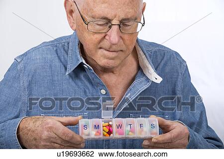 Man with pill organiser View Large Photo Image Stock Image - Man with pill organiser. Fotosearch