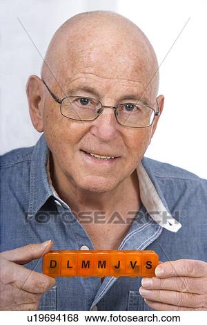 Stock Photo - Man with pill organiser. Fotosearch