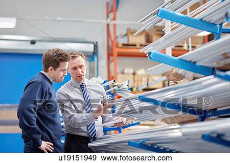 Manager and factory worker checking shelves of metal rods in roller blind factory View Large Photo Image Stock Photo - Manager and factory worker checking shelves of metal rods in roller blind factory. Fotosearch