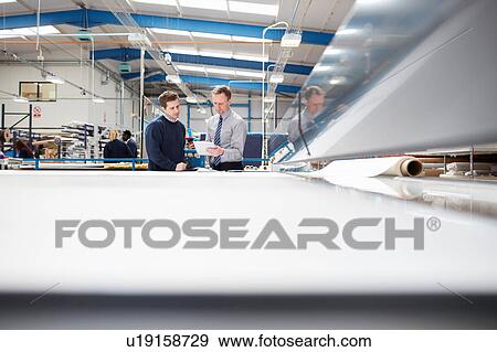 Manager and factory worker discussing work in roller blind factory View Large Photo Image Stock Photo - Manager and factory worker discussing work in roller blind factory. Fotosearch