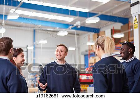 Stock Image - Manager explaining to team in manufacturing factory. Fotosearch