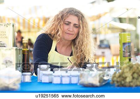 Stock Photography - Market trader with variety of olive oil produce. Fotosearch