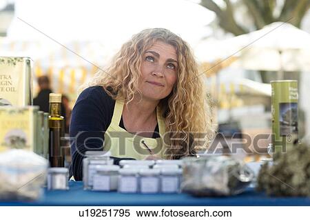 Stock Photography - Market trader with variety of olive oil produce. Fotosearch
