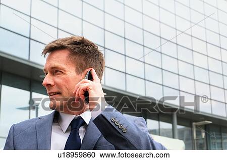 Mature businessman outdoors, using smartphone View Large Photo Image Stock Image - Mature businessman outdoors, using smartphone. Fotosearch