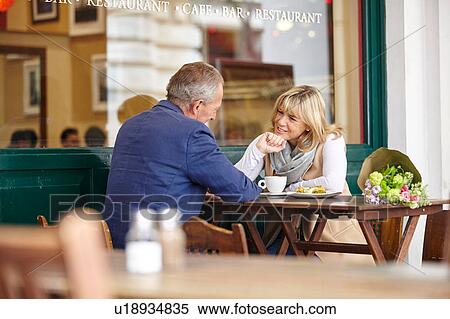 Mature dating couple chatting together at sidewalk cafe table View Large Photo Image Stock Photography - Mature dating couple chatting together at sidewalk cafe table. Fotosearch