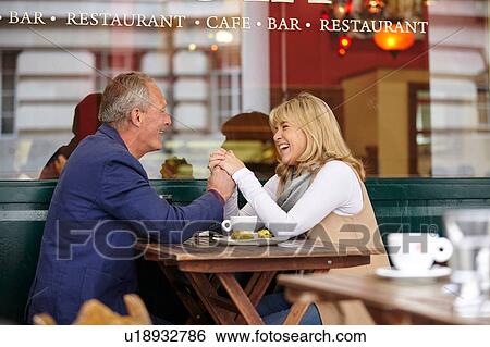 Mature dating couple holding hands at sidewalk cafe table View Large Photo Image Stock Photograph - Mature dating couple holding hands at sidewalk cafe table. Fotosearch