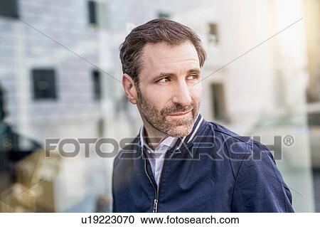 Mature man looking over his shoulder in city View Large Photo Image Stock Image - Mature man looking over his shoulder in city. Fotosearch