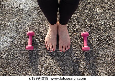Mature woman standing barefoot, hand weights on floor beside her, elevated view, focus con feet View Large Photo Image Stock Photo - Mature woman standing barefoot, hand weights on floor beside her, elevated view, focus con feet. Fotosearch