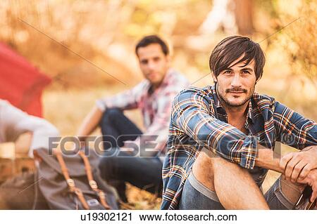 Stock Image - Men camping in forest, Deer Park, Cape Town, South Africa. Fotosearch