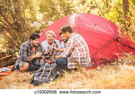 Men drinking beer whilst preparing food on camping stove in forest, Deer Park, Cape Town, South Africa View Large Photo Image Stock Photo - Men drinking beer whilst preparing food on camping stove in forest, Deer Park, Cape Town, South Africa. Fotosearch
