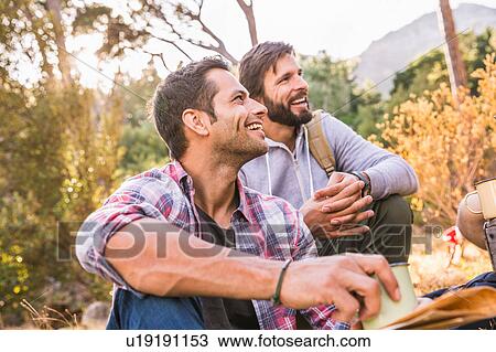 Stock Image - Men having coffee together in forest, Deer Park, Cape Town, South Africa. Fotosearch