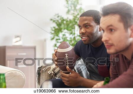 Men sitting in lounge holding ball looking away View Large Photo Image Stock Photograph - Men sitting in lounge holding ball looking away. Fotosearch