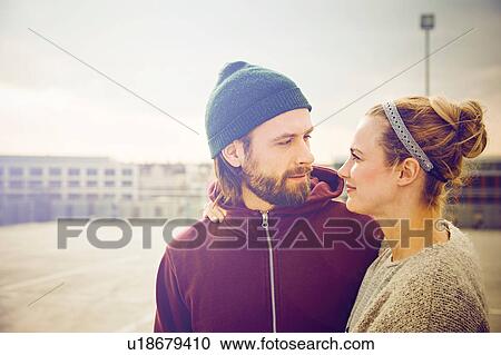 Mid adult couple gazing at each other on rooftop parking lot View Large Photo Image Stock Image - Mid adult couple gazing at each other on rooftop parking lot. Fotosearch