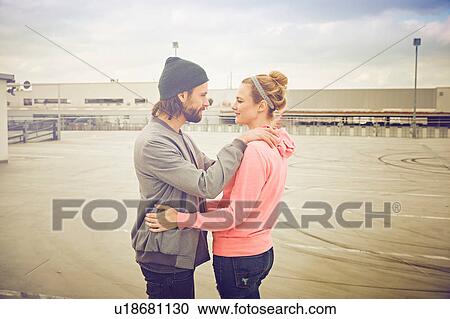 Mid adult couple gazing at each other on rooftop parking lot View Large Photo Image Stock Image - Mid adult couple gazing at each other on rooftop parking lot. Fotosearch