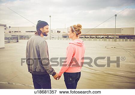 Mid adult couple holding hands on rooftop parking lot View Large Photo Image Stock Photo - Mid adult couple holding hands on rooftop parking lot. Fotosearch