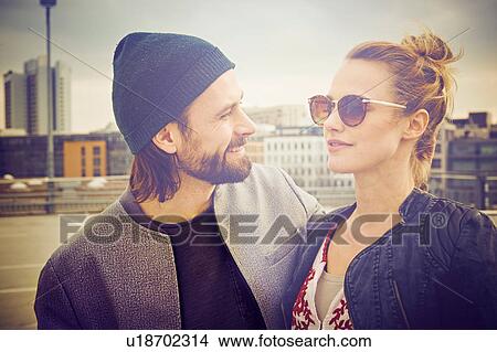 Picture - Mid adult couple on rooftop parking lot. Fotosearch