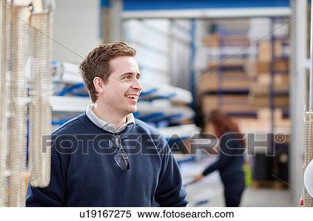 Stock Photography - Mid adult male worker in manufacturing factory. Fotosearch