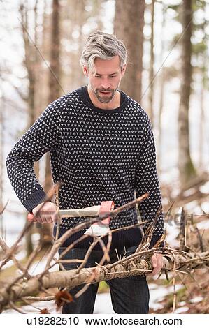 Mid adult man, outdoors, holding axe, chopping tree branch View Large Photo Image Stock Image - Mid adult man, outdoors, holding axe, chopping tree branch. Fotosearch