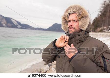 Stock Image - Mid adult man standing beside lake, German Alps, Germany. Fotosearch