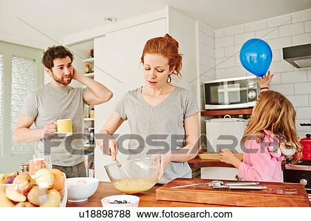 Mid adult woman whisking eggs at kitchen counter for family breakfast View Large Photo Image Stock Photo - Mid adult woman whisking eggs at kitchen counter for family breakfast. Fotosearch