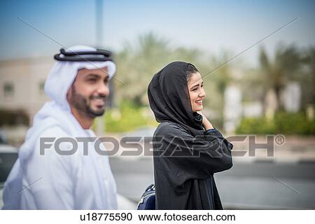 Middle eastern couple wearing traditional clothing walking along street, Dubai, United Arab Emirates View Large Photo Image Stock Image - Middle eastern couple wearing traditional clothing walking along street, Dubai, United Arab Emirates. Fotosearch