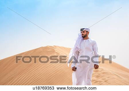 Middle eastern man wearing traditional clothes on desert dune, Dubai, United Arab Emirates View Large Photo Image Stock Image - Middle eastern man wearing traditional clothes on desert dune, Dubai, United Arab Emirates. Fotosearch