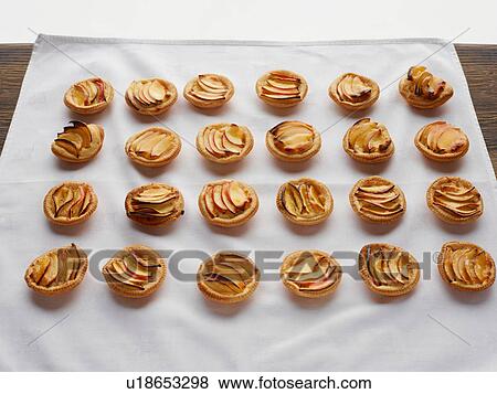 Miniature frangipane apple tarts on tablecloth View Large Photo Image Stock Photo - Miniature frangipane apple tarts on tablecloth. Fotosearch