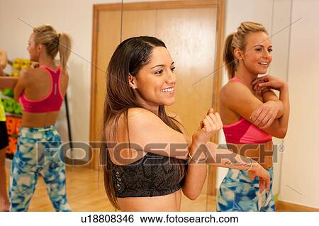 Mirror image of people in gym doing arm stretching exercises View Large Photo Image Stock Photograph - Mirror image of people in gym doing arm stretching exercises. Fotosearch