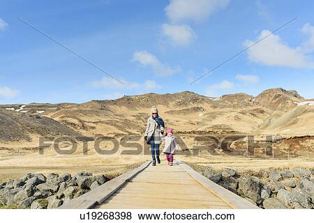 Mother and daughter, holding hands, walking along wooden pathway, Hveragerdi, Iceland View Large Photo Image Stock Photo - Mother and daughter, holding hands, walking along wooden pathway, Hveragerdi, Iceland. Fotosearch