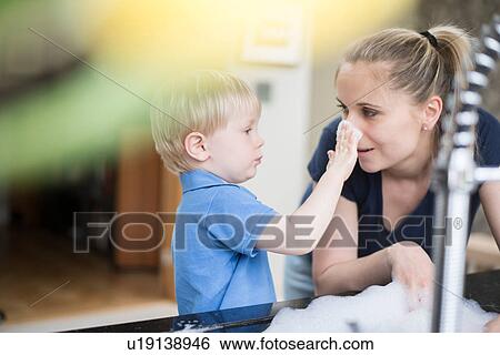 Mother and son doing washing up together, playing with bubbles View Large Photo Image Stock Photograph - Mother and son doing washing up together, playing with bubbles. Fotosearch