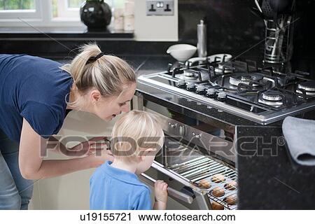 Mother and son peeking in oven to check on baking View Large Photo Image Stock Image - Mother and son peeking in oven to check on baking. Fotosearch