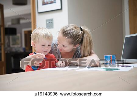 Stock Photograph - Mother helping son to write. Fotosearch