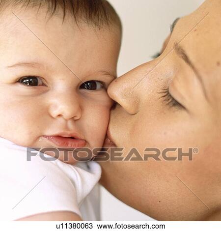 Stock Image - Mother kissing baby girl. Fotosearch