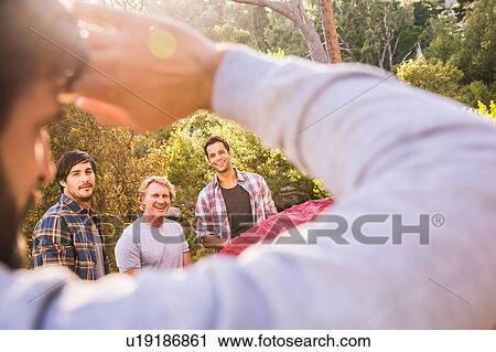 Over shoulder view of four men putting up tent in forest, Deer Park, Cape Town, South Africa View Large Photo Image Stock Image - Over shoulder view of four men putting up tent in forest, Deer Park, Cape Town, South Africa. Fotosearch