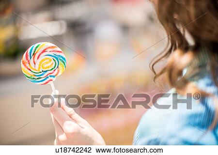Over shoulder view of woman with lollipop, Dubai, United Arab Emirates View Large Photo Image Stock Image - Over shoulder view of woman with lollipop, Dubai, United Arab Emirates. Fotosearch