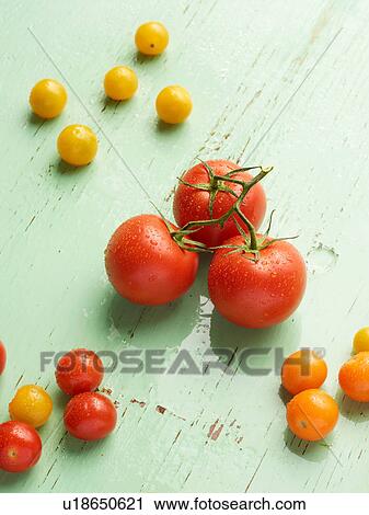 Stock Image - Overhead view of tomatoes on green background. Fotosearch