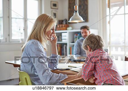 Stock Photo - Parents and son working in home office. Fotosearch