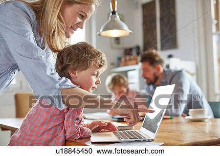 Stock Image - Parents and sons working in home office. Fotosearch